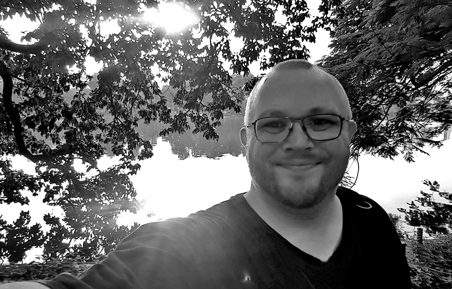 Black and white portrait of Shaun Holroyd near a lake